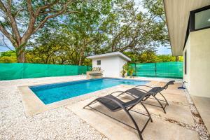a swimming pool with two chairs next to a house at Casa Montana Azul @ Catalina Cove in Brasilito