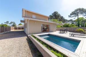 a house with a swimming pool in the backyard at Villa Cazaline - Piscine Privée in La Teste-de-Buch