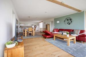 a living room with a red couch and a table at Ferienwohnung Auf Dem Haldershof in Wangen im Allgäu