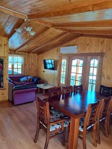 a dining room with a wooden table and chairs at Hostal Robinson in Puerto Puyuhuapi