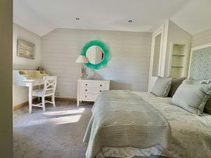 a bedroom with a bed and a desk and a mirror at 2-Bed Cottage Garden Views near the Peak District in Macclesfield