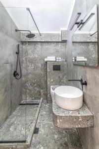 a bathroom with a sink and a glass shower at ICONIC Marévia Beachfront Pefkohori in Pefkohori +32 photos