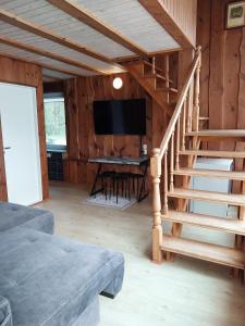 a living room with a staircase and a television at Birutės Vila in Palanga