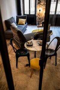 a living room with a table and chairs and a couch at "Un Lieu Unique" le Gold et le Cocon in Annecy +52 photos