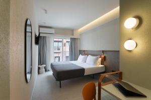a hotel room with a bed and a mirror at Evripides Hotel in Athens