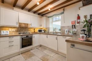 ベバリーにあるGranary 3 bedroomsの白いキャビネットと窓のあるキッチン