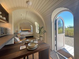 a kitchen and living room with an open archway at Quarrywood Glamping in Tenby