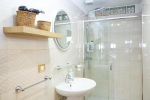 a white bathroom with a sink and a shower at Casa Vacanze San Pietro in Canosa di Puglia