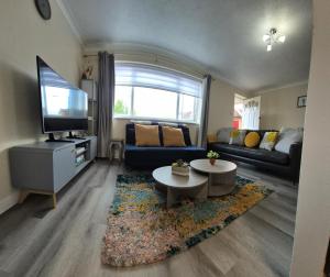 a living room with a couch and a tv at Cosy 2 Bedroom House Stevenage Old town Close to Train Station Free Parking Sleeps 4-6 in Stevenage