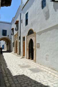 un callejón con un edificio blanco con una puerta en Dar Ben Gacem en Túnez