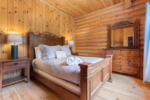 a bedroom with a bed in a log cabin at Le Cerf 53 Fiddler Lake in Mille-Isles +41 photos