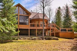 a large wooden house with a large deck at Le Cerf 53 Fiddler Lake in Mille-Isles