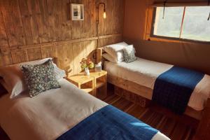 グラストンベリーにあるBramley Lodgeのベッドが2つと窓がある小さな部屋