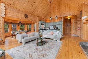 a living room filled with furniture and a kitchen at Le Cerf 53 Fiddler Lake in Mille-Isles