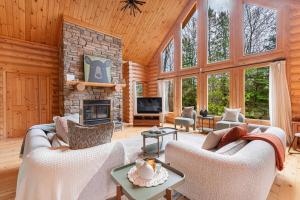 a living room with two couches and a fireplace at Le Cerf 53 Fiddler Lake in Mille-Isles