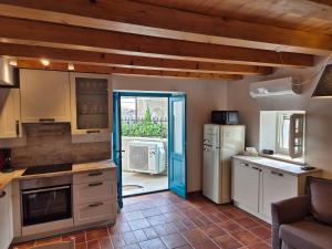 a kitchen with a blue door and a refrigerator at Akvamarin Stone House Istria in Medulin