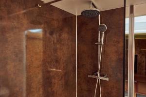a shower with a shower head in a bathroom at Russet Lodge in Glastonbury +9 photos