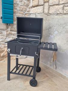 a grill on a cart with a laptop on it at Akvamarin Stone House Istria in Medulin