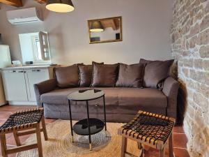 a living room with a couch and two tables at Akvamarin Stone House Istria in Medulin +8 photos