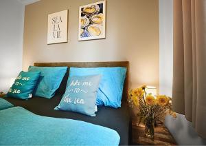 a room with a bed with blue pillows at Beachhouse Strandglück nur ca 100m bis zum Strand in Hulshorst +6 photos
