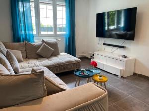 ein Wohnzimmer mit Couch und Flachbildfernseher in der Unterkunft Maison proche Nancy Golf, Forêt & Calme à Pulnoy in Pulnoy