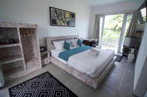 ein Schlafzimmer mit einem großen Bett und einem großen Fenster in der Unterkunft The shortcut rooms in Canggu