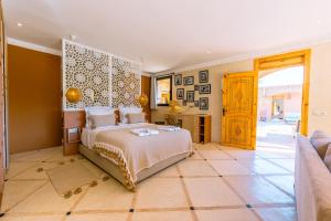 a bedroom with a bed and a table and a couch at Villa Naël Marrakech in Marrakech
