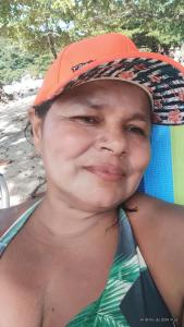 a man wearing an orange hat sitting on a surfboard at Camping e pousada dos sonhos in Carvalhos +11 photos