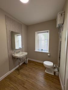 a bathroom with a sink and a toilet at Drumlinn Cottage in Bridge of Cally +16 photos