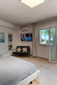 a bedroom with a bed and a couch and a window at Oasi Elegante Piscina di Lusso - vista panoramica By Sicily Home Solutions in Alcamo