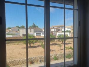 a window with a view of a field and buildings at Casa Braila in Campo Arcís