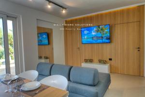 a living room with a blue couch and a table at Oasi Elegante Piscina di Lusso - vista panoramica By Sicily Home Solutions in Alcamo