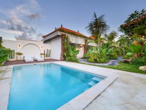 ein Swimmingpool vor einem Haus in der Unterkunft Kanchana Cottages in Uluwatu