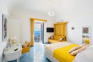sypialnia z łóżkiem, biurkiem i kanapą w obiekcie Casa Nilde w mieście Positano