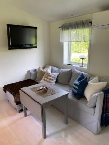 a living room with a couch and a table at Cozy cottage on horse farm in Bollnäs in Bollnäs +23 photos