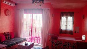 a red living room with a couch and a large window at Dar El Amen Appartements in Mahdia +76 photos