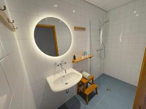 a white bathroom with a sink and a mirror at Boutique tent 'Pruum' op een unieke plek in het groen met luxe bed in Vorden
