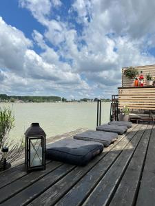 a row of pillows on a dock with the water at Splav Casa Luna in Ostružnica