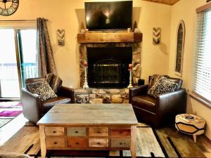 a living room with two chairs and a fireplace at Horsin’ Around-Cabin with a peaceful covered deck. in Ponderosa Heights
