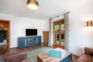a living room with a tv and a table at Haus Kreiznegge in Inzell