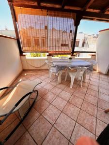 a patio with a table and chairs on a balcony at House on the beach in Lido Marini