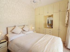 a bedroom with a white bed and a mirror at Killelton Cottage in Killelton