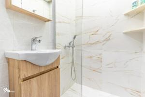 a bathroom with a sink and a shower at Four 4Season - Beach Access & Amazing View Retreat in Vraná