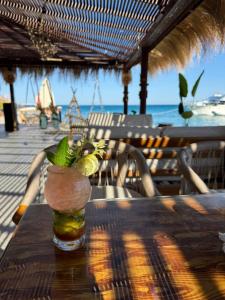 a glass vase sitting on a table with a drink at Shellghada Blue Beach in Hurghada