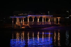 a building with lights on the water at night at Shellghada Blue Beach in Hurghada