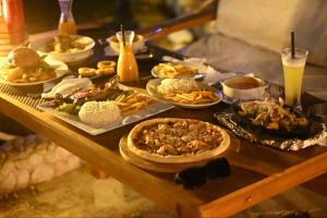 a table with many plates of food on it at Shellghada Blue Beach in Hurghada