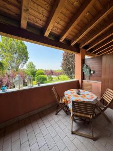 a patio with a table and chairs on a porch at Green Garda Holidays - Garda Lake in Castelnuovo del Garda