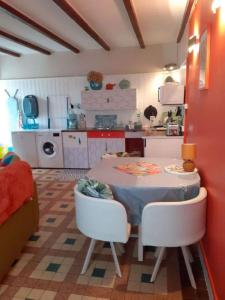 a kitchen with a table and two chairs and a table and a kitchen at Rêve du Revert in Roz-sur-Couesnon