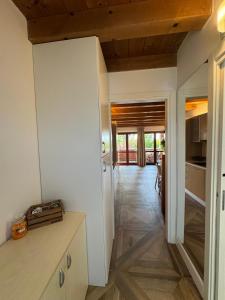 a kitchen with white walls and wooden ceilings at Green Garda Holidays - Garda Lake in Castelnuovo del Garda +29 photos