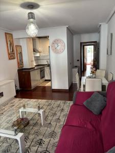 a living room with a couch and a clock on the wall at Residencial Torres in Castro-Urdiales